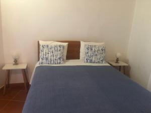 a bedroom with a bed with two side tables at Sudoeste Guest House in Odeceixe
