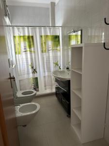 a white bathroom with a toilet and a sink at Villa Amaryllis in Pulsano +13 photos