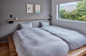 Postel nebo postele na pokoji v ubytování 綯 -NAU-