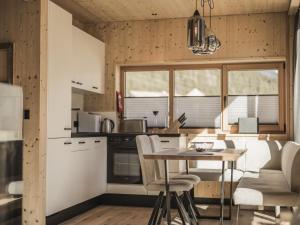 a kitchen with white cabinets and a table and chairs at Chalet in Bichlbach near Ski Slopes in Bichlbach