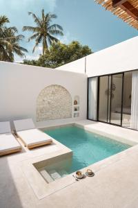a swimming pool in the middle of a house at Kasih 2 - Villa with private pool in Gili T in Mantaak