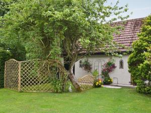 a tree in front of a house with a gate at The Studio in Warkworth