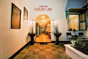 a hallway with a sign that reads waiting neptune at Indonesia Hotel Malioboro in Yogyakarta +84 photos