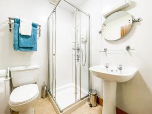 a bathroom with a shower and a toilet and a sink at Fourpenny Studio - Uk34745 in Embo +2 photos
