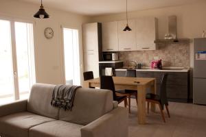 a living room with a couch and a table and a kitchen at Gioja suite in Quartu SantʼElena