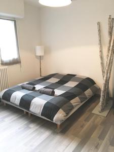 a bed with a black and white comforter in a room at Home sweet Home by Victoria in Aix-les-Bains