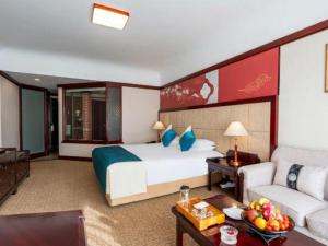 a hotel room with a bed and a couch at Wonderport International Hotel in Lijiang
