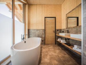 a bathroom with a large tub and a sink at Chalet in Bichlbach near Ski Slopes in Bichlbach +33 photos