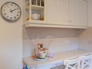 a kitchen counter with a clock and a tea cup at Fairways in Beadnell