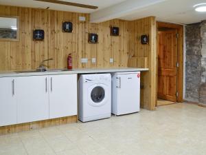 a kitchen with a washing machine and a sink at The Granary in Holy Island