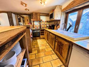 a kitchen with wooden cabinets and a large sink at Chalet Necou - Magnifique Chalet au pied des pistes MAE-3754 in Les Menuires