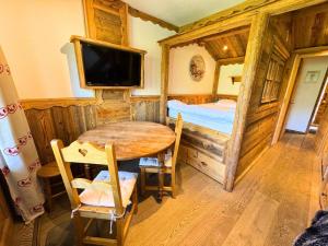 a room with a table and a bed and a television at Résidence Necou - Studio déco style chalet en bord de pistes MAE-5954 in Les Menuires