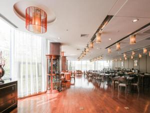 蘇州市にあるRamada by Wyndham Suzhou Luzhiのテーブルと椅子と窓のあるダイニングルーム