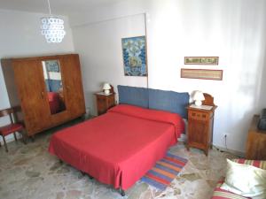 パレルモにあるAppartamento Bluの赤いベッド1台(赤い毛布付)が備わるベッドルーム1室が備わります。
