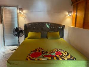 Ecotourism Bukit Lawang Bungalow في بوكيت لاوانج: غرفة نوم مع سرير مع لحاف أخضر