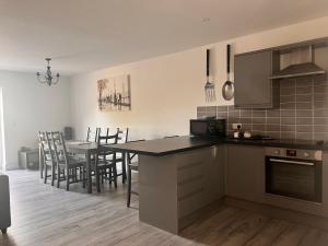 a kitchen and dining room with a table and chairs at Footpath Cottages 