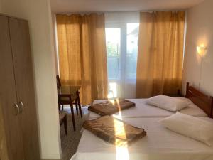 a hotel room with two beds and a window at Bungalowri Exotic in Costinesti