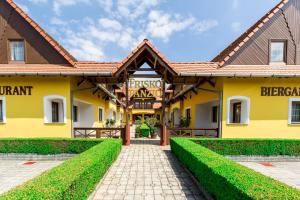 a yellow building with a pathway in front at Friskó Panzió in Zalakaros