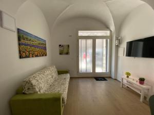 un salon avec un canapé et une télévision dans l'établissement La Casa sul Corso, à Ascoli Piceno
