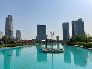 a large pool of water with a tree in a city at Luxury Apartment Tashkent City boulevard Happy Home in Tashkent