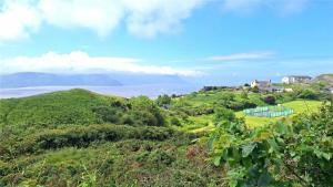 una casa su una collina con l'oceano sullo sfondo di Cosy little house on Great Orme a Llandudno