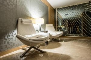 two white chairs in a room with a lamp at New California in Xindian