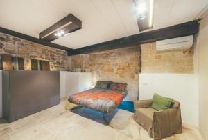 um quarto com uma cama e uma cadeira em La pergola em Polignano a Mare