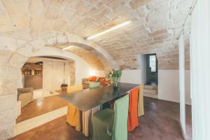 uma cozinha e sala de jantar com uma parede de pedra em La pergola em Polignano a Mare