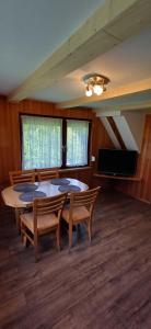 a dining room with a table and chairs and a flat screen tv at Domek pod Zielonym Dachem in Rytro