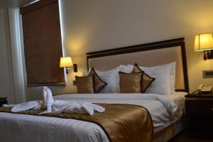 a hotel room with a bed with towels on it at The Legend in Allahābād