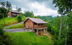 eine Blockhütte auf einem Hügel mit einem Haus in der Unterkunft Always in Gatlinburg