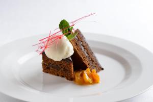a piece of cake with ice cream on a white plate at Villa Nicolli Romantic Spa Resort - Adults Only in Riva del Garda