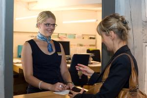 a woman is talking to another woman in an office at Gasthof Hirschen in Eglisau