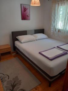 a bed with white sheets and pillows in a room at Villa Giulia in Bihać