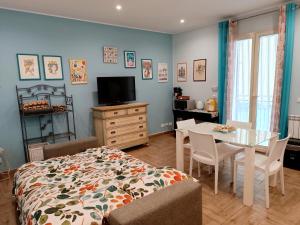 a bedroom with a bed and a table and a tv at Casa Azzurra in Giardini Naxos