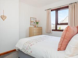 a white bedroom with a bed and a window at Hebridean Holiday House in Stornoway +6 photos