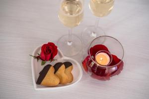 a plate of cookies and roses and wine glasses at Villa Nicolli Romantic Spa Resort - Adults Only in Riva del Garda