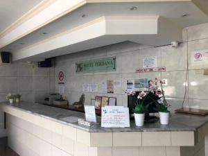 a counter in a restaurant with flowers on it at Hotel Perdana in Lawas