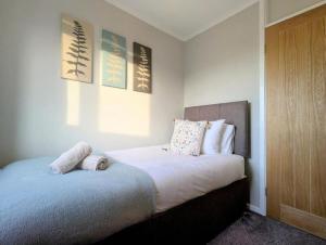 a bedroom with a bed with two towels on it at Luxury 4BR Retreat, Garden, Parking, Modern Comfort in Balderton