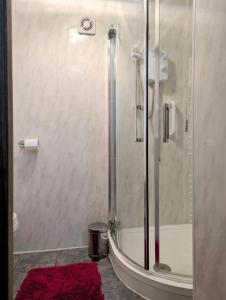 a bathroom with a shower with a red rug at Luxury 4BR Retreat, Garden, Parking, Modern Comfort in Balderton +13 photos