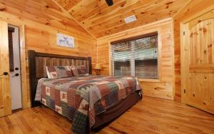 Un dormitorio con una cama en una cabaña de troncos en Carsons Place, en Gatlinburg
