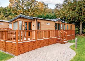 a large wooden cabin with a wooden fence at Cheddar Woods Resort And Spa in Cheddar