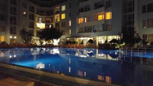 a swimming pool in front of a building at night at Niko Apartments in Sunny Beach