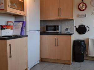 a kitchen with a white refrigerator and a microwave at Quarry Cottage in Bethesda