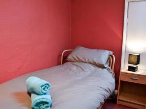 a bed in a room with a red wall at Quarry Cottage in Bethesda +3 photos