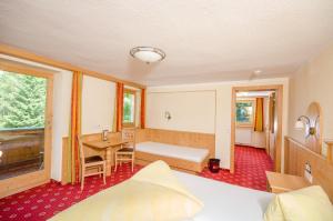 a hotel room with a bed and a desk at Alpengasthof Enzianhof in Zell am Ziller