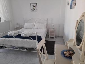 biała sypialnia z łóżkiem i lustrem w obiekcie Sea paradise villas - Seaside & private jacuzzi w mieście Oia