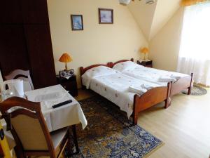 1 dormitorio con 2 camas, mesa y sillas en Willa Anna Maria, en Wysowa-Zdrój