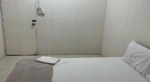 - une chambre avec un lit blanc et une porte blanche dans l'établissement OYO 90514 Habeeb Lodge Sandakan, à Sandakan