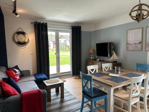 a living room with a table and a couch at Apartament szafirowy z basenem koło Łeby in Żarnowska